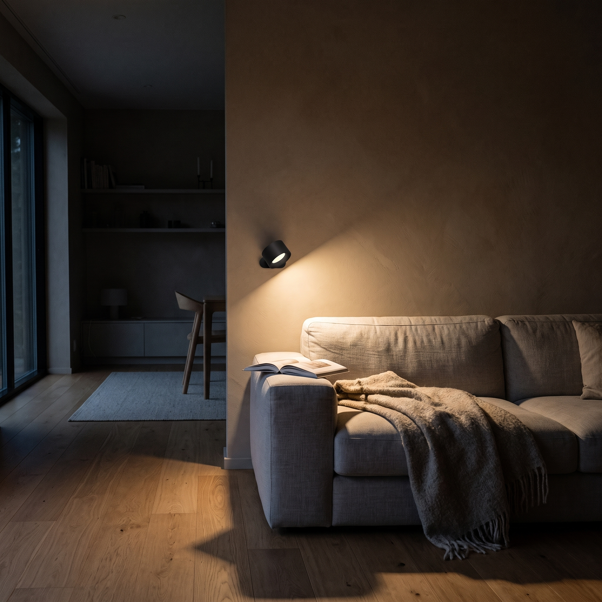 Wall lamp lighting a sofa corner in the evening, the only light on in the room